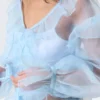 Blusa transparente con cuello en V y volantes – Azul claro