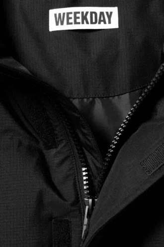 Chaqueta acolchada con capucha y ribete de piel sintética – Negro