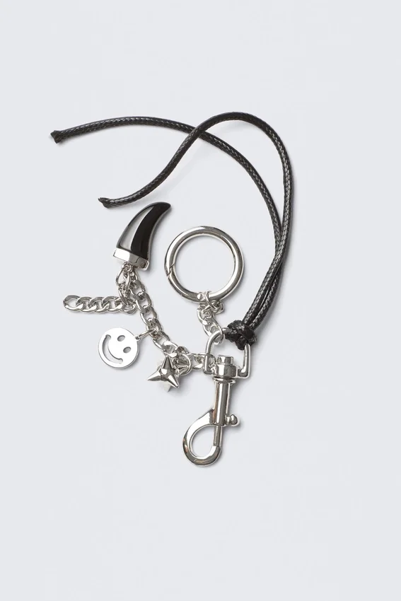 Llavero con múltiples dijes – Metal/cordón negro Llavero con múltiples dijes – Metal/cordón negro