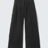 Pantalones anchos de talle bajo con efecto arrugado – Negro