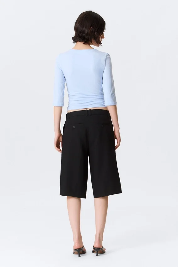 Pantalones cortos de traje de talle bajo y corte holgado con pliegues – Negro Pantalones cortos de traje de talle bajo y corte holgado con pliegues – Negro