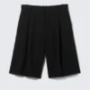 Pantalones cortos de traje de talle bajo y corte holgado con pliegues – Negro Pantalones cortos de traje de talle bajo y corte holgado con pliegues – Negro