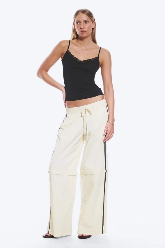 Pantalones de chándal de nailon con cremallera desmontable – Beige – Rayas negras Pantalones de chándal de nailon con cremallera desmontable – Beige – Rayas negras