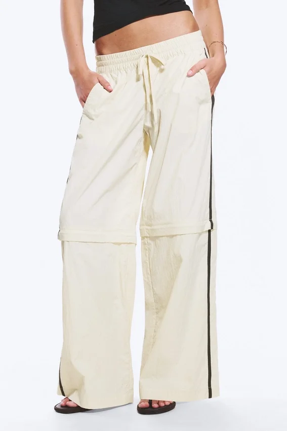 Pantalones de chándal de nailon con cremallera desmontable – Beige – Rayas negras Pantalones de chándal de nailon con cremallera desmontable – Beige – Rayas negras