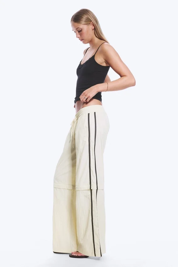 Pantalones de chándal de nailon con cremallera desmontable – Beige – Rayas negras Pantalones de chándal de nailon con cremallera desmontable – Beige – Rayas negras
