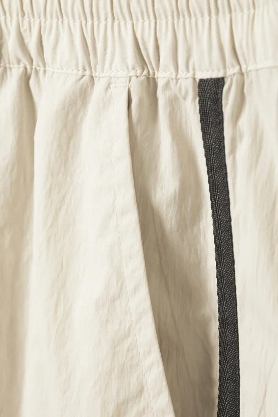 Pantalones de chándal de nailon con cremallera desmontable – Beige – Rayas negras Pantalones de chándal de nailon con cremallera desmontable – Beige – Rayas negras
