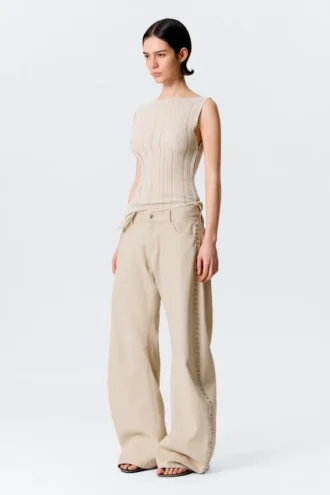 Pantalones holgados de talle bajo con tachuelas y corte acampanado – Beige