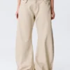 Pantalones holgados de talle bajo con tachuelas y corte acampanado – Beige Pantalones holgados de talle bajo con tachuelas y corte acampanado – Beige